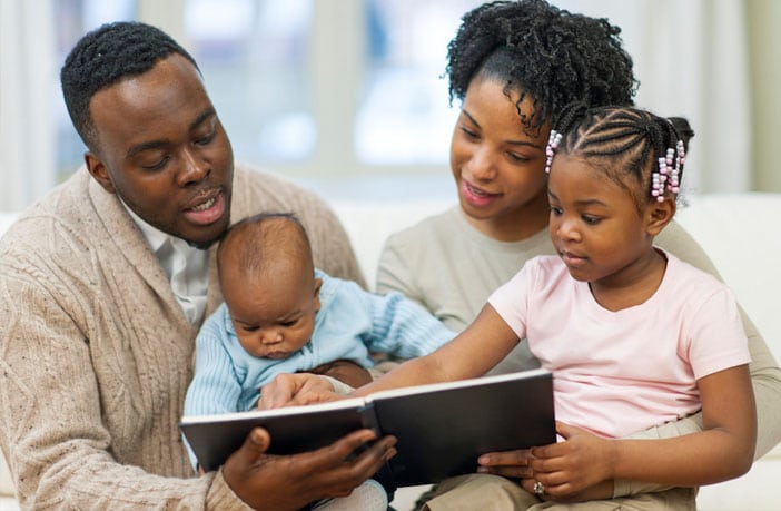 family reading to baby son and daughter