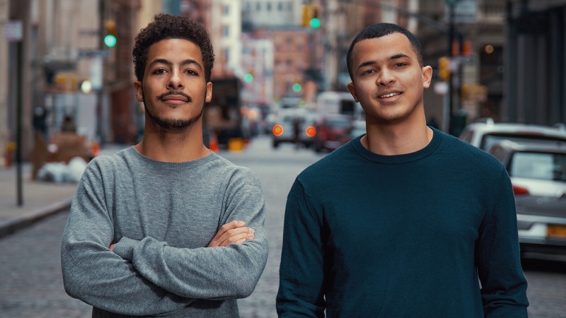 two black college students looking confident city street background