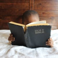 Young Black Boy Reading A Bible